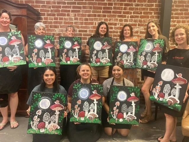 Guests at The Artist Workshop holding their paintings